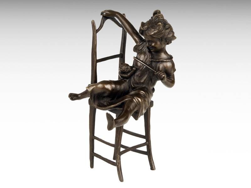 Escultura de bronze - Menina sentada na cadeira brincando com o seu ga